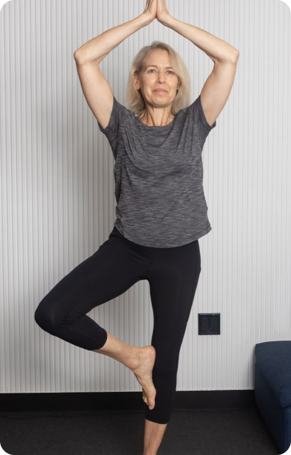 elderly woman in vrikshasana yoga pose