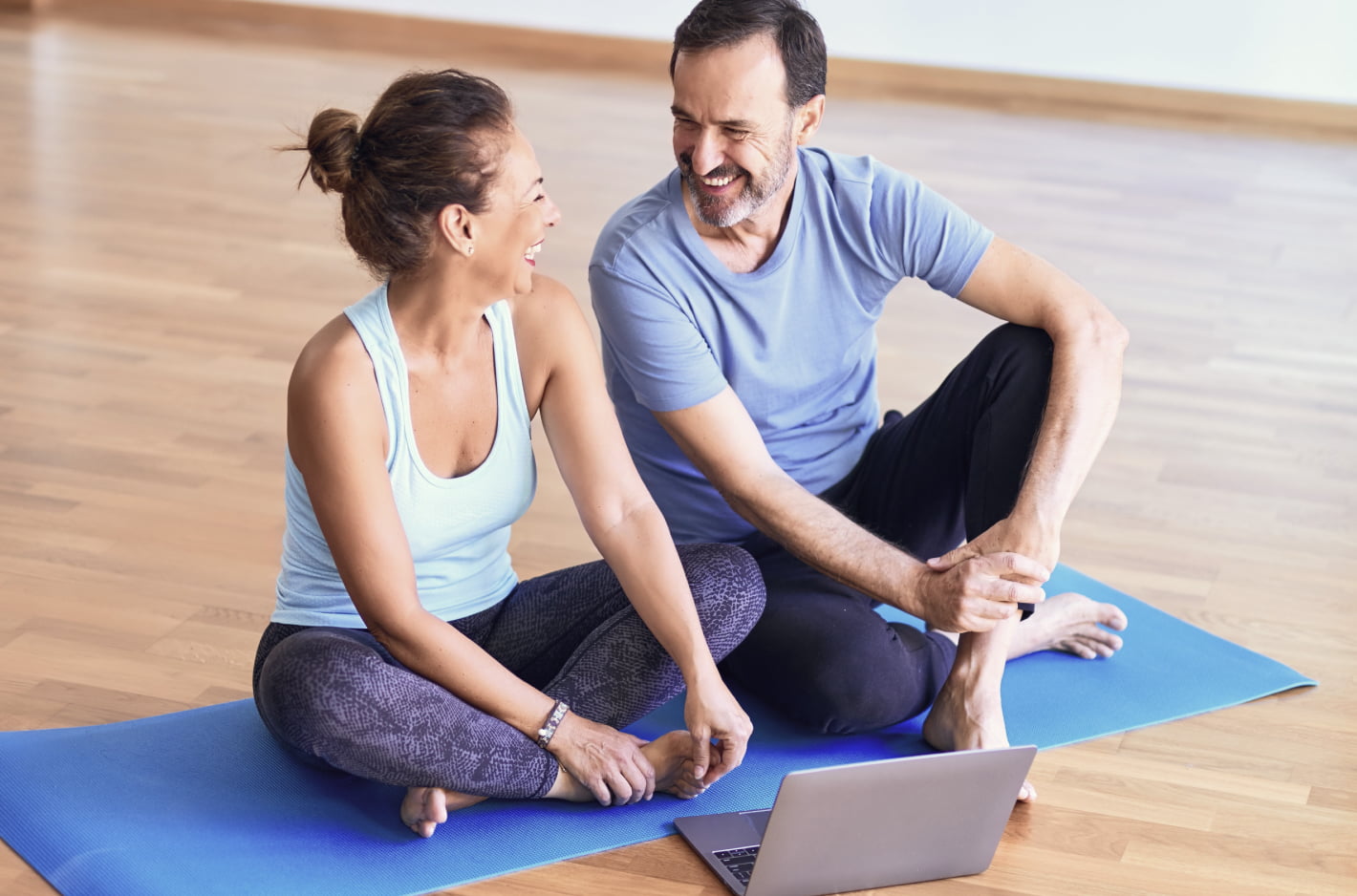 Man and woman chat on yoga mat